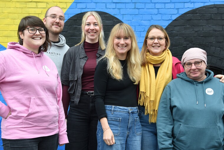 Fünf Menschen lächeln in die Kamera